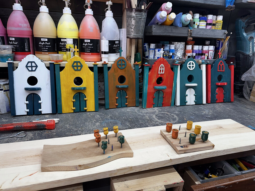 Hand-painted Spanish Mission birdhouse fronts drying in the workshop